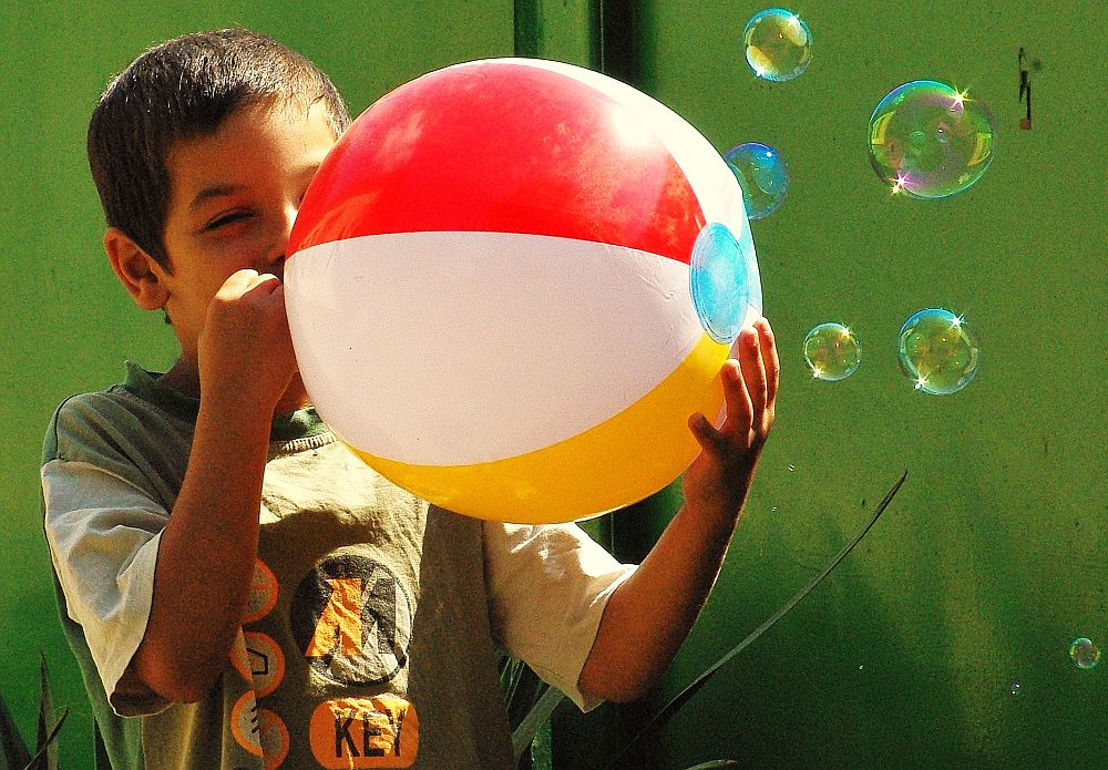 Kid playing with a balloon ball.