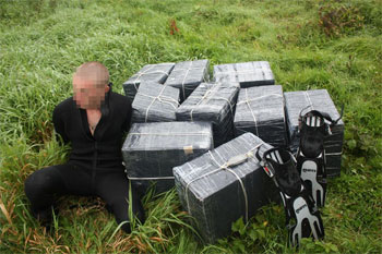 A smuggler nabbed by border guards in 2010 after attempting to swim across the Nemunas River, trailing boxes of cigarettes. Photo courtesy of the Lithuanian Interior Ministry.